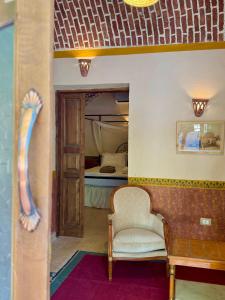 a living room with a chair and a bed at El Juneina Villas - Luxury Boutique Villas Near Valley of the Kings in Luxor