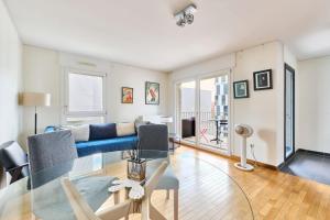 a living room with a blue couch and a table at Bright apartment paris 19-metro 7 in Paris