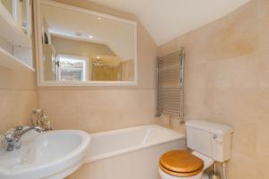 a bathroom with a sink and a toilet and a tub at Charming Cotswold Cottage on Church Green, Witney in Witney +13 photos