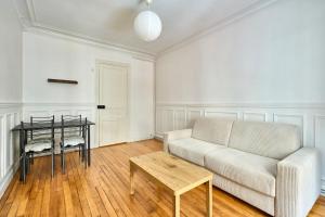 a living room with a couch and a table at Ideal Apartment near the Seine Métro 765 in Paris