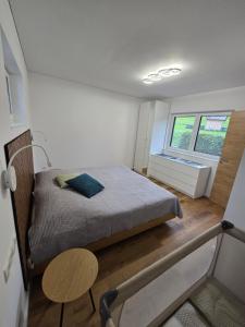 a small bedroom with a bed and a window at Ländle Lodge, Ferienwohnung nahe Bregenz, Lindau und Bodensee in Hohenweiler