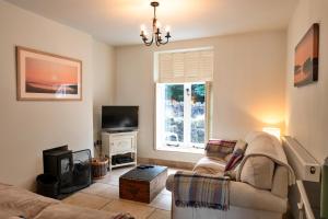 ein Wohnzimmer mit Sofa und Fernseher in der Unterkunft Finest Retreats - River Cottage in Lynmouth