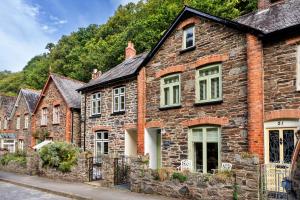 eine Reihe von Backsteinhäusern in einer Straße in der Unterkunft Finest Retreats - River Cottage in Lynmouth