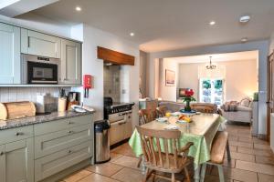 eine Küche mit einem Tisch und Stühlen in einer Küche in der Unterkunft Finest Retreats - River Cottage in Lynmouth