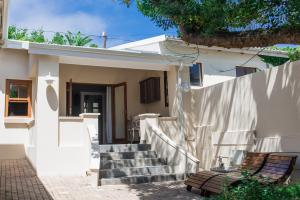 モッセル・ベイにあるLe Port Guesthouseの階段と柵のある白い家