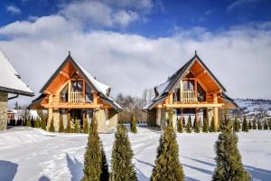 a couple of log homes in the snow at Zbójeckie Sioło in Bukowina Tatrzańska