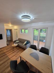 a living room with a couch and a table and chairs at Ländle Lodge, Ferienwohnung nahe Bregenz, Lindau und Bodensee in Hohenweiler