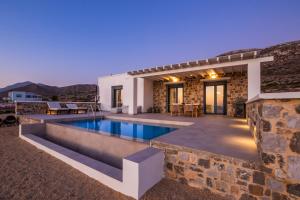 a villa with a swimming pool in the desert at Terramare Villas Karpathos in Foinikion