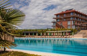 a large swimming pool with chairs and a building at Kachreti Ambassadori Golf Resort, 16 Villa in Kachretʼi