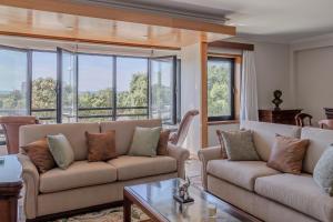 a living room with two couches and large windows at Vista Atlântica-Vila do Conde in Vila do Conde