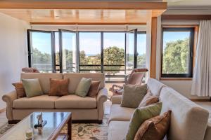 a living room with two couches and a table at Vista Atlântica-Vila do Conde in Vila do Conde