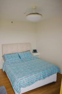 a bedroom with a bed with a blue blanket at The Loop Tower Downtown City Centre Comfy 2bR in Pontud