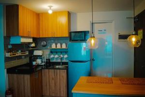 a kitchen with a blue refrigerator and wooden cabinets at The Loop Tower Downtown City Centre Comfy 2bR in Pontud