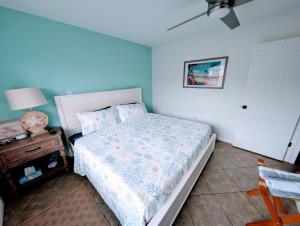 ココアビーチにあるSteps to Beach - Spacious 2BR - Arcade & Resort Backyardのベッドとランプ付きのナイトスタンドのある寝室 +27枚の写真