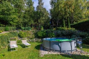 een hot tub in de tuin met 2 ligstoelen bij Casa Nature Bogo in (( Pleteno ))