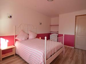 a bedroom with a white bed with pink walls at Holiday Home in Saint-Clément near the Sea in Osmanville