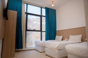a hotel room with two beds and a large window at فندق ديار الكرم1 - diyar alkaram1 in Makkah