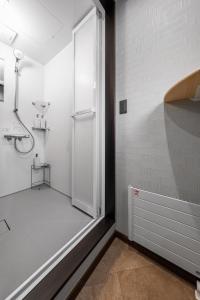 a bathroom with a shower and a glass door at The Horizon Residence in Makubetsu