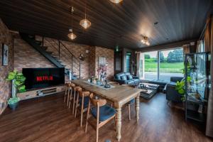 a living room with a wooden table and a tv at The Horizon Residence in Makubetsu