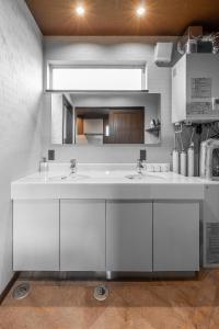 a white bathroom with two sinks and a mirror at The Horizon Residence in Makubetsu