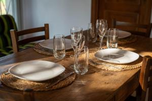 a wooden table with plates and wine glasses on it at Castello di Lisignano - Storia Pace e Tradizione in Agazzano