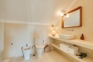 ein Badezimmer mit Waschbecken, Toilette und Spiegel in der Unterkunft Charneca Caparica Casa Rey by Hopstays in Vale de Cavalos + 75 Fotos
