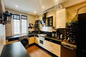 a kitchen with a black counter top and a stove at 16th 10 minutes from the Eiffel Tower Metro line 9 in Paris