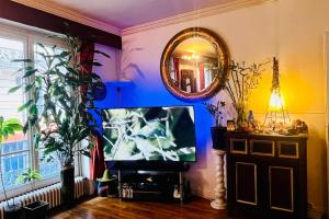 a living room with a tv and a mirror at 16th 10 minutes from the Eiffel Tower Metro line 9 in Paris