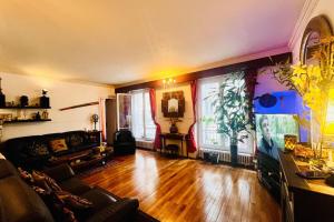 a living room with a couch and wooden floors at 16th 10 minutes from the Eiffel Tower Metro line 9 in Paris +2 photos