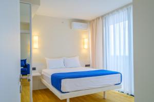 a bedroom with a bed with a blue blanket and a window at Orbi City Collection in Batumi +45 photos