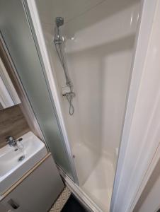eine Dusche mit Glastür neben einem Waschbecken in der Unterkunft Elegant caravan home in Hampshire, United Kingdom 6 guests 2 bedroom 3 beds 1 sofa bed 2bathrooms in Hayling Island