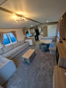 ein Wohnzimmer mit Sofa und Tisch in der Unterkunft Elegant caravan home in Hampshire, United Kingdom 6 guests 2 bedroom 3 beds 1 sofa bed 2bathrooms in Hayling Island