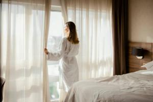 a woman in a white dress looking out of a window at The Granary Apartments in Copenhagen