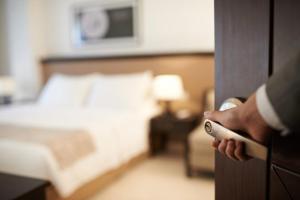 a person opening a door to a bedroom with a bed at The Granary Apartments in Copenhagen