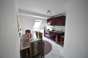 cocina con armarios rojos y mesa de madera en Familienparadies auf dem Reiterhof, en Bad Nenndorf