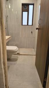 アーポラにあるHotel Coco Goaのトイレ、洗面台、窓のあるバスルーム