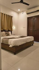 アーポラにあるHotel Coco Goaの木製のヘッドボードが付いた大きなベッドのある寝室 +3枚の写真