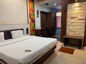 a hotel room with a bed and a dining room at Vaishali Deluxe Comfort in Tumkūr