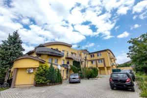 a yellow building with cars parked in a parking lot at 2-room apartment near Xbionic-sphere and Bratislava in Nová Lipnica