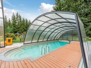 a swimming pool with a retractable arch over it at Forest Retreat in Jägersgrün in Bad Reiboldsgrün