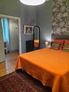 a bedroom with a bed with an orange blanket at Le Jardin Secret & Spa - Appartement 2 Chambres in Saint-Brieuc