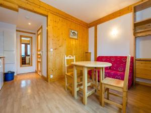 a dining room with a table and a red couch at Résidence & Spa La Grande Cordée - Combloux in Combloux