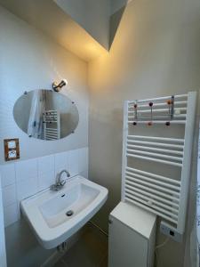 a white bathroom with a sink and a mirror at Chambre cozy avec sdb privée à 7min de la gare in Redon