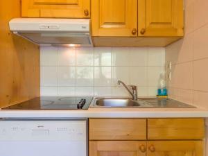 a kitchen with a sink and a stove at Résidence & Spa La Grande Cordée - Combloux in Combloux