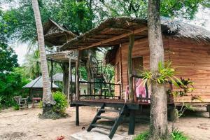 a wooden house with a bench in front of it at Sunset Beach Bungalow Koh Pu in Ko Jum