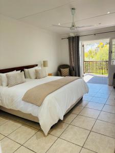 a bedroom with a large bed and a balcony at Good Hope Farm in Sunland