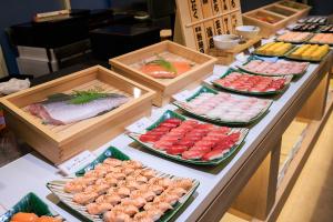 a buffet line with different types of food in boxes at Maholova Minds Miura in Miura