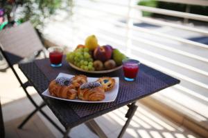 un tavolo con un piatto di prodotti da forno e un cesto di frutta di Casa Relax Suite a Civitanova Marche