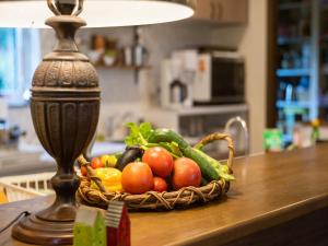 a basket of vegetables on a table next to a lamp at アルパインロッジ in Inawashiro