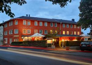 ein großes rotes Gebäude mit einem Hotel in einer Straße in der Unterkunft Privathotel Stickdorn in Bad Oeynhausen